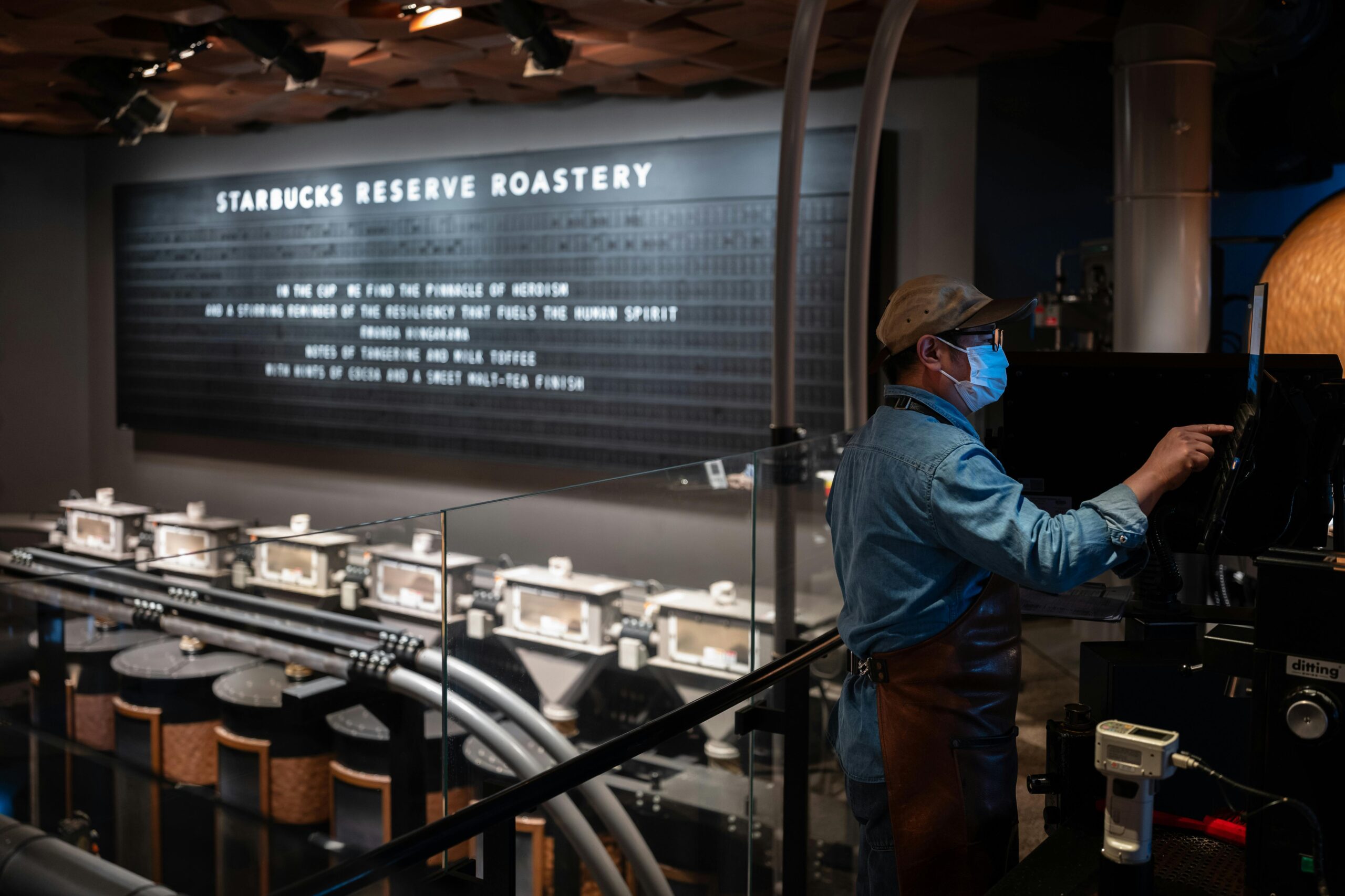 h1-team-img-04-100x100 A barista operates machinery at Starbucks Reserve Roastery, showcasing the coffee production process.